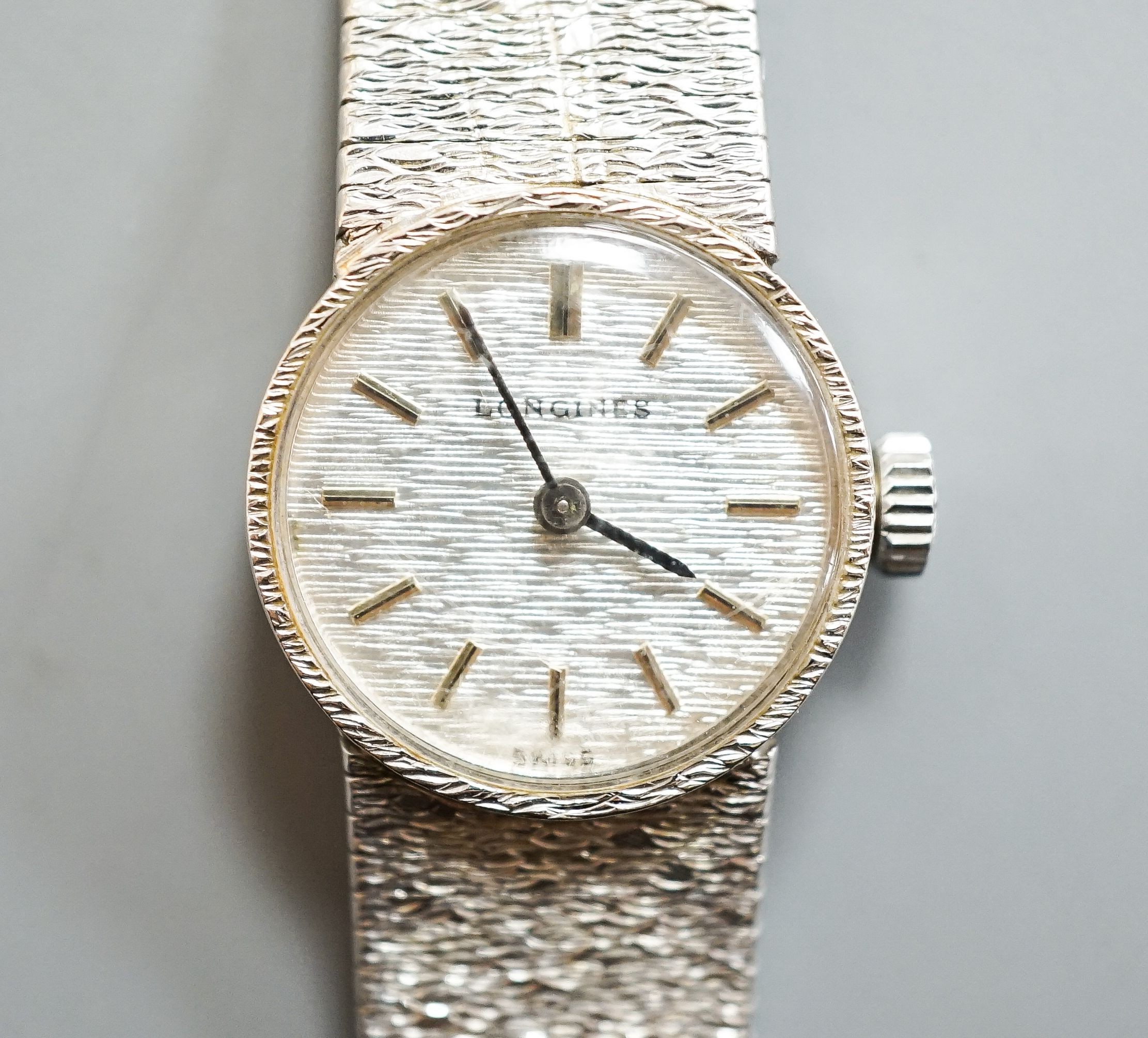 A lady's textured 9ct white gold Longines manual wind wrist watch, case diameter 19mm, overall length 15.2cm